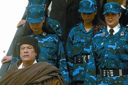 Muammar Khadafy baja del avión en el aeropuerto de Bruselas acompañado de parte de su guardia amazónica, las mujeres que protegían su seguridad