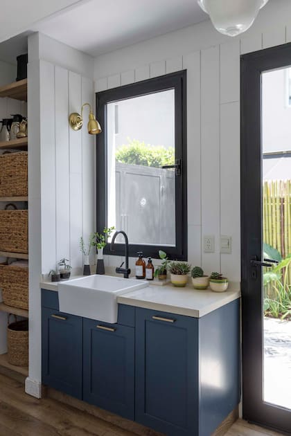 Mueble azul (mezcla de los tonos 8269 y 8270 de Sinteplast) combinado con estantes de melamina (Ritta Estudio) y mesada de Silestone ‘Blanco Norte’. Bacha (Ponthus) con grifería monocomando (Peirano).