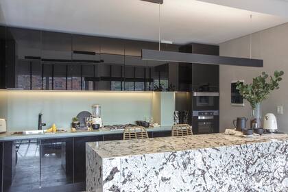 Mueble de cocina (Dwell Cocinas) con alacenas y bajomesada de Rauvisio ‘Negro Brillante’ (Rehau). Mesada y alzada de Silestone ‘Posidonia Green’ (Canteras). Horno y anafe (Longvie).