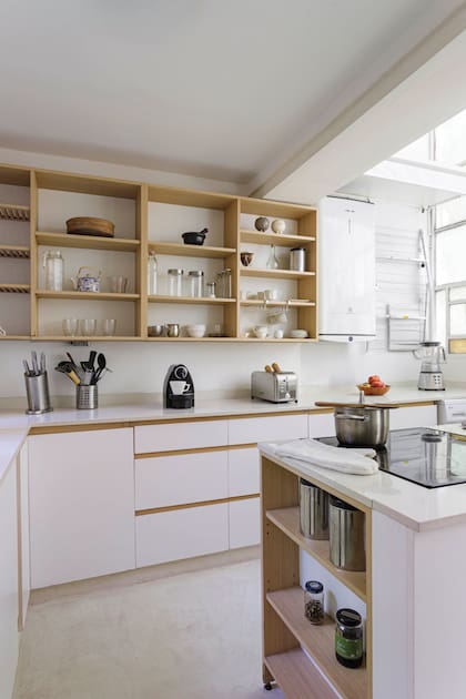 Mueble de cocina en melamina blanca y pino tea recuperada durante la obra, diseñado por el Estudio.