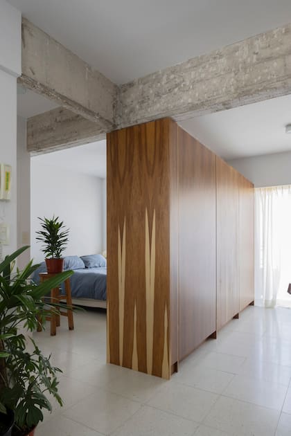 Mueble de madera que funciona a modo de divisor entre la habitación y el lugar de trabajo.