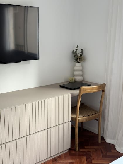 Mueble de MDF 'Sahara' (Arquitectura Prado + Bacigaluppi Cerban) con frente varillado, silla de petiribí y fibras (Kikely). Florero (Forma de Pez).