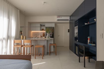 Mueble diseñado y ejecutado por el Estudio, laqueado en azul ‘Star- Studded 0620,’ que contrasta con las paredes en ‘Luna Moon 0017’ (Sinteplast). Iluminación general (New Light). Banquetas (Taller Posible).