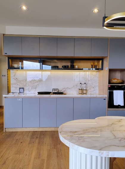 Mueble en melaminas de Faplac 'Paraíso' y gris 'Basalto'. Mesada y tapa de la isla en 'Fantasy White' (De Stefano). Pisos 'Natural Oak' (Patagonia Flooring).