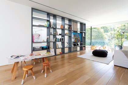 Mueble hecho a medida (Estudio LDMB), mesa ‘Mini Maxxi Table’ y bancos infantiles ‘Oriente Milk Stool’ laqueados (Krethaus). Un gran placard para los juguetes y mucho control de mamá mantienen la biblioteca ordenada.