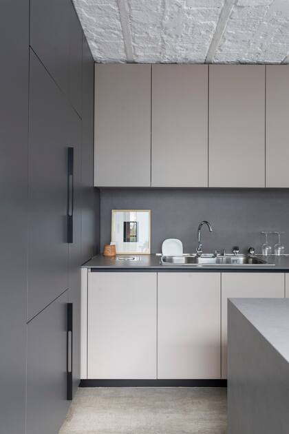 Muebles de cocina (Arq. Flor Fontana) con bajomesada y alacenas de melamina ‘Gris Arcilla’ (Egger). Mesada y alzada de Neolith ‘Pietra di Piombo’ (Marmolería Gaona).