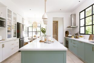 Muebles de cocina (ART Arquitectos) con frente laqueado verde malva, tono al que los dueños llegaron después de muchas pruebas. El vajillero reitera el diseño del bajomesada opuesto, pero en blanco.