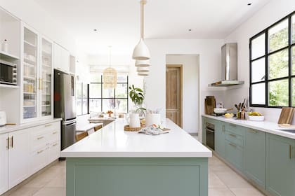 Muebles de cocina (ART Arquitectos) con frente laqueado verde malva, tono al que los dueños llegaron después de muchas pruebas. El vajillero reitera el diseño del bajomesada opuesto, pero en blanco.