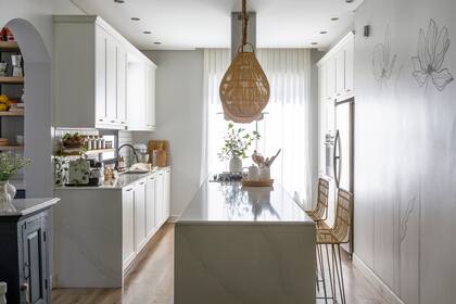 Muebles de cocina ‘Celebración’ blanco mate (De Otro Tiempo). Mesadas de Silestone ‘Calacatta’ (Ragolia). Banquetas (Basket Shop). Lámparas de techo (Compañía Nativa).