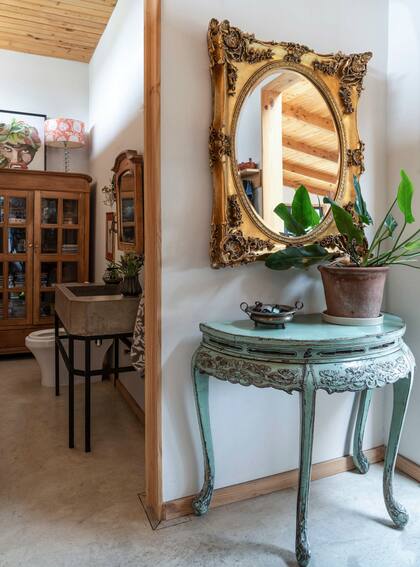 Muebles de estilo francés patinados o dorados a la hoja en el hall de entrada junto el al toilette.