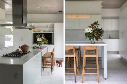 Muebles de madera laqueada en blanco (Balunek). La isla se diferencia por el tono gris claro. Mesadas de Purastone (Marmolería Gallus). Banquetas de petiribí y pisos de terrazo.
