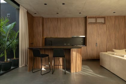 Muebles de melamina nogal (Faplac) con alzada de granito 'Brasil' con terminación leather (De Stefano por Progettit Marmolería). Heladera panelable.