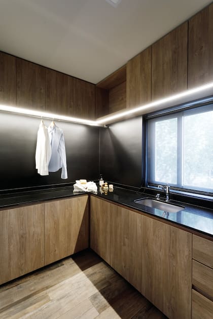 Muebles enchapados con melamina ‘Gaudí’ (Faplac) y mesada de granito ‘Negro Absoluto’ (De Stefano).