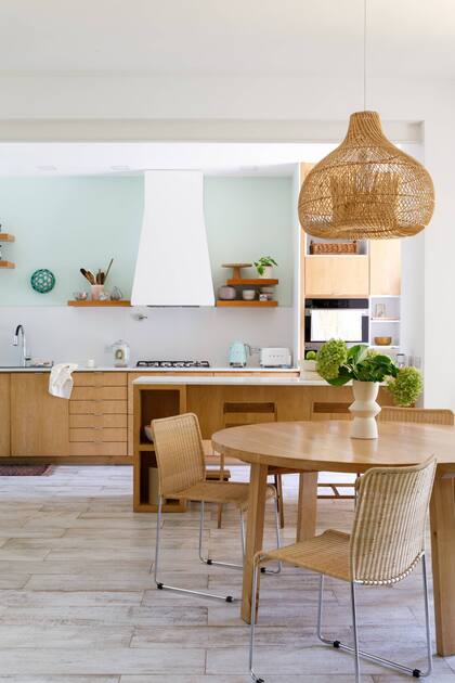 Muebles y barra (Raúl Magnarelli). Mesa redonda (Mercato). Sillas (Jaim). Lámpara (Compañía Nativa). Piso de porcelanato ‘Legni’ (Ilva).