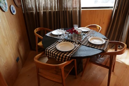 Mesa quemada redonda y sillas de teca (Estudio 11.11 Leticia Rocco). Cortinas de lino Hunter Duglas (SNOB).