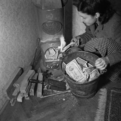 Mujer usando pengős como combustible para la chimenea.
