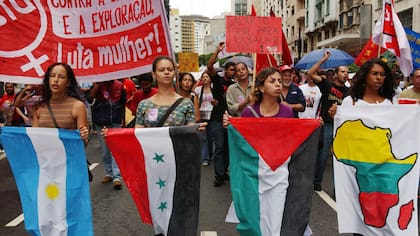 Mujeres brasileñas sostienen banderas y gritan consignas contra la guerra durante una manifestación para conmemorar el Día Internacional de la Mujer en Sao Paulo, Brasil en 2003