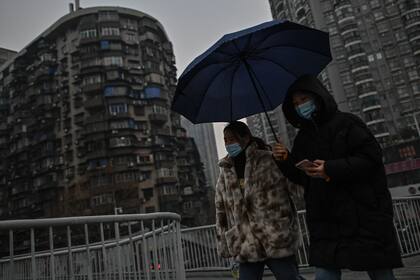 Mujeres caminan a lo largo de un puente peatonal en Wuhan, provincia central de Hubei en China, el 21 de enero de 2021