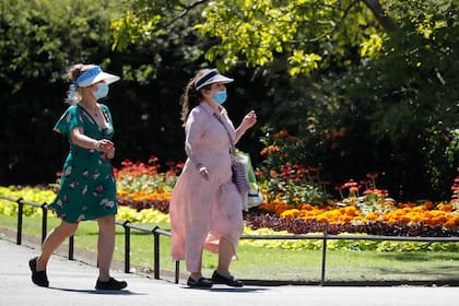 Mujeres con mascarillas caminando por el parque Regents en el centro de Londres el 30 de julio de 2020