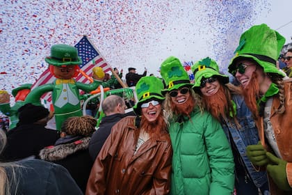 Mujeres con sombreros de duende y barbas falsas sonríen durante el desfile anual del Día de San Patricio en Boston. (AP Foto/Charles Krupa)