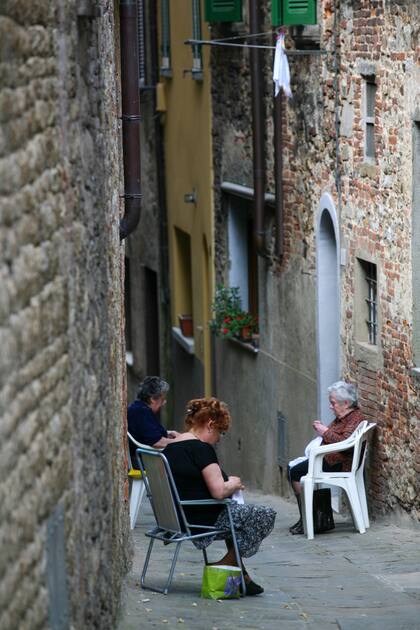 Mujeres cosiendo en una calle de Lucignano.