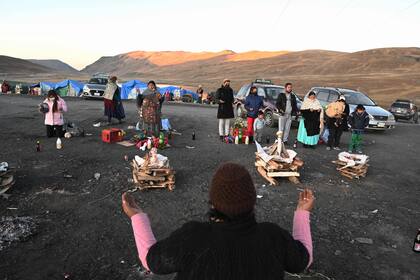 Mujeres indígenas rezan antes de quemar fetos secos de llama como ofrenda a la "Madre Tierra" en Bolivia.