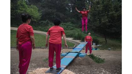Mujeres norcoreanas practican un juego tradicional de see-saw en un parque en Pyongyang