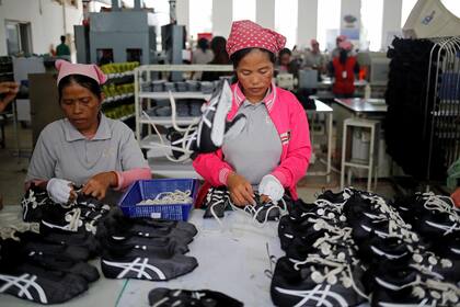 Mujeres trabajan en la línea de producción en Complete Honor Footwear Industrial
