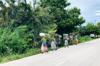 Mujeres transportan objetos en sus cabezas en Kendwa, Tanzania. Los autos y las bicicletas son poco comunes