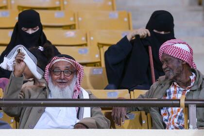 Mujeres y hombres grandes en las tribunas de las canchas saudíes; el gobierno y los ejecutivos de la liga esperan que las cifras de asistencia a los estadios sigan aumentando