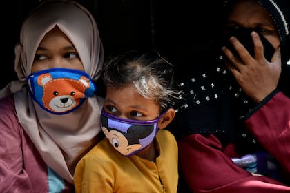 Mujeres y niñas utilizan un barbijo en Indonesia en plena pandemia de coronavirus