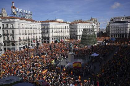 Multitudes con banderas españolas llenan la céntrica Puerta del Sol durante una protesta convocada por el Partido Popular Conservador de España en Madrid, España, el 12 de noviembre de 2023. (AP/Joan Mateu Parra, File)