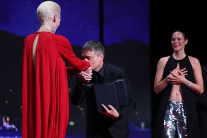 Mungiu, con la Palma de Oro en su mano, saluda a la actriz Tilda Swinton, encargada del anuncio oficial. Al fondo, Renate Reinsve luce conmovida