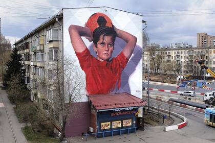 Mural en Rusia: un niño saca un lateral y ofrece la pelota a la ciudad.
