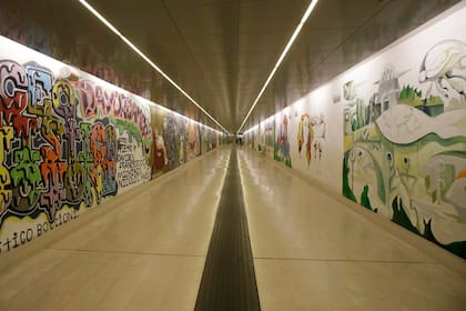 Murales adornan las paredes de una estación de subte vacía en Milán, Italia, el viernes 28 de febrero de 2020. Debido al brote del virus COVID-19 en el norte de Italia, la bulliciosa metrópoli de Milán se parecía más a una ciudad fantasma, ya que los trabajadores se quedaron en sus casa y el turismo