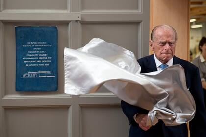 El príncipe Felipe revela una placa al final de su visita al Richmond Adult Community College de Richmond, al suroeste de Londres (8 de junio de 2015).