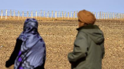 Zghala, una mujer del Sáhara Occidental, que mira la cerca en el área de Al-Mahbes mientras acompaña a su hijo de 14 años para que vea la cerca que separa el Sáhara Occidental controlado por el Frente Polisario de Marruecos