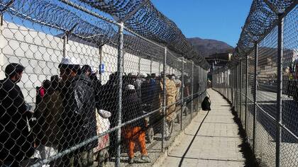 Afganos que esperan cruzar la frontera entre Pakistán y Afganistán en el puesto fronterizo de Torkham, Pakistán