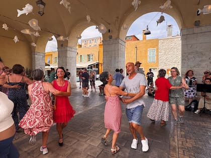 Músicos callejeros en los arcos del mercado de flores Cours Saleya, en Niza