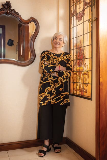 Muy sonriente, con look en negro y dorado, apoyada contra un vitraux que trajo de su casa anterior. “Nos mudamos cuando los chicos se fueron y quedamos solos”, cuenta.
