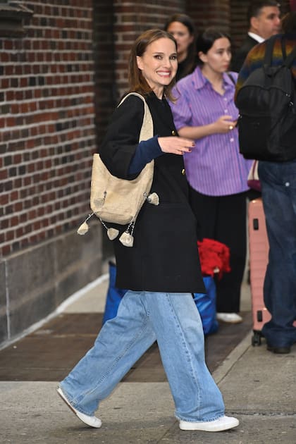 Muy sonriente,
Natalie sale
de los estudios
de CBS con
un cómodo
outfit de jeans
y zapatillas.
Detrás de ella,
su estilista con
el vestido rojo
con el que entró puesto en una bolsa.