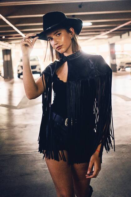 Myla Cambiaso desfiló lookeada con sombrero, saco con flecos y minishort.