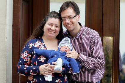 Una pareja posa con su bebe recién nacido, al salir del mismo hospital donde nació el tercer hijo de la pareja real