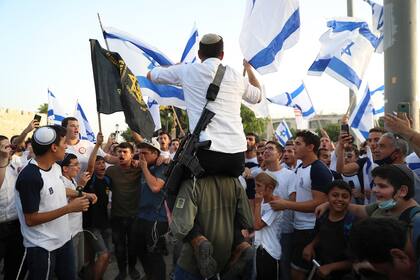 Nacionalistas israelíes hacen flamear banderas de Israel durante una marcha el 10 de mayo