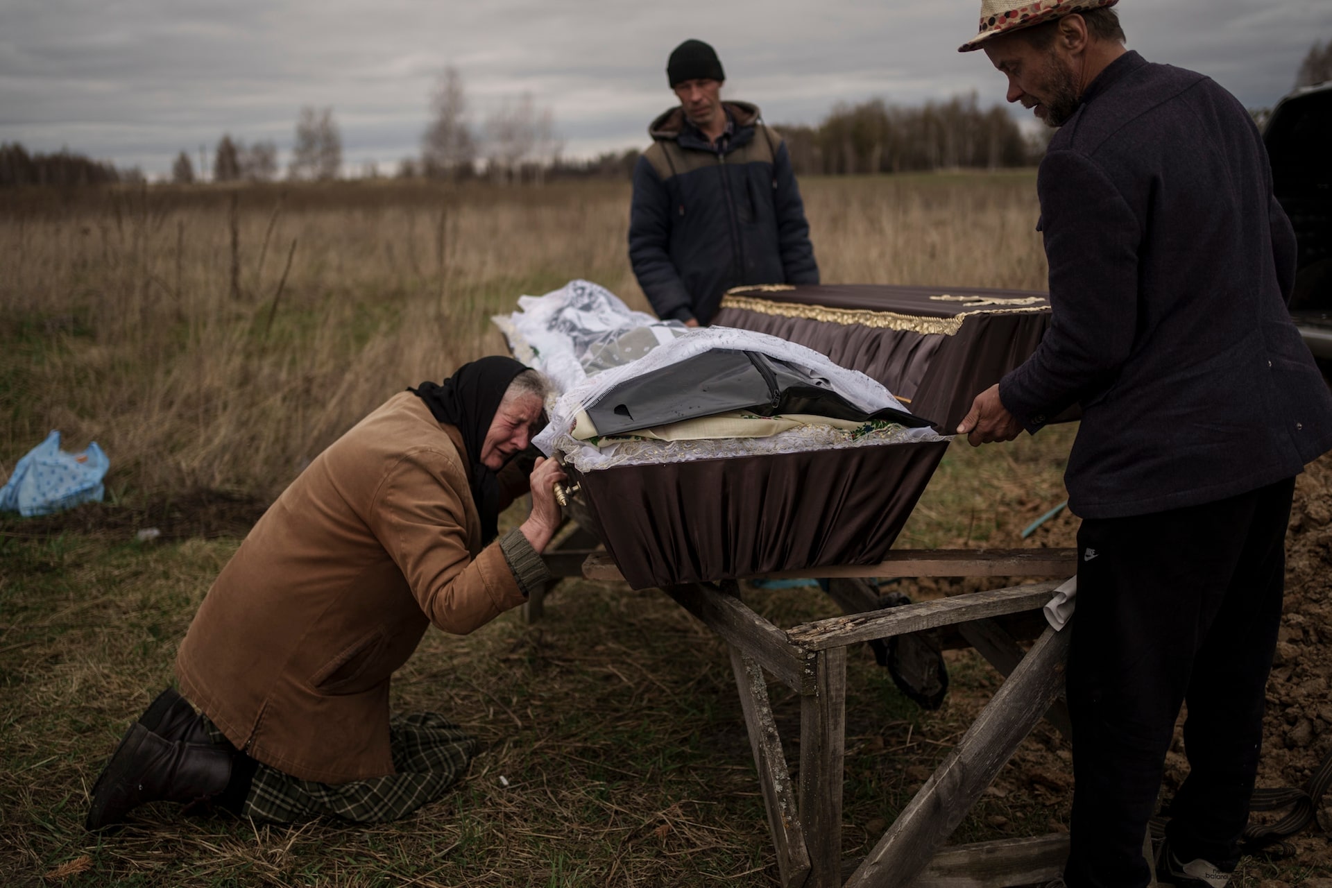 Nadiya Trubchaninova, de 70 años, llora junto al lado del féretro con los restos de su hijo, durante el funeral en el cementerio de Mykulychi, en las afueras de Kiev, Ucrania, el 16 de abril de 2022. 