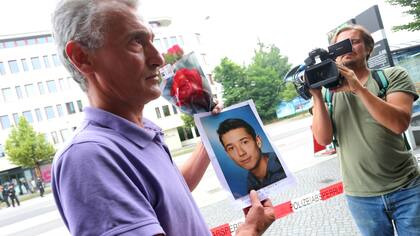 Naim Zabergja sostiene una foto de Dijamant, su hijo muerto en el centro comercial Olympia