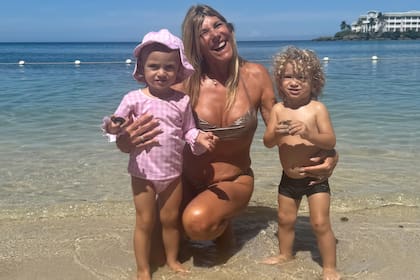 Nancy con sus nietos a orillas del mar.