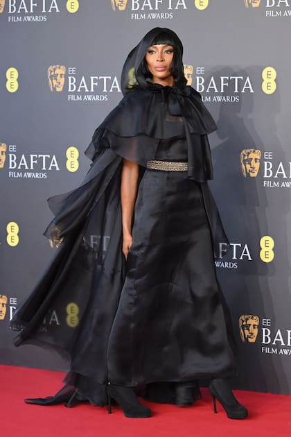 Naomi Campbell aportó dramatismo con un Chanel Alta Costura coronado con una capa de corte irregular con capucha, y gran lazo.