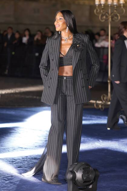 Naomi Campbell optó por un tailleur de raya diplomática que combinó con un top a lunares del que se desprendía una larga cola.