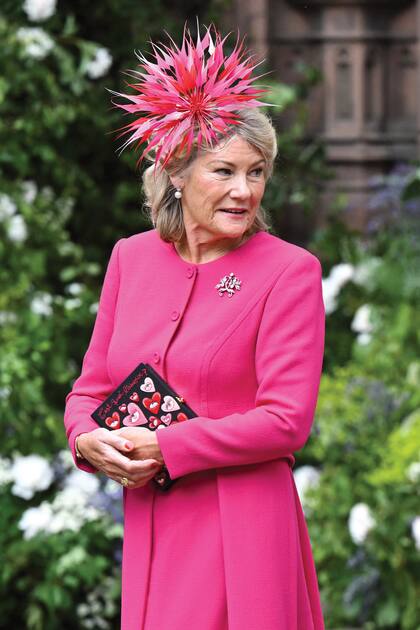 Natalia Grosvenor, que se decantó por un vestido-tapado fucsia de Eponine London para la boda de su hijo, estuvo casada durante casi cuarenta años con Gerald Grosvenor, padre de Hugh. El clutch (modelo “What is love?”) es de Olympia Le-Tan Paris.